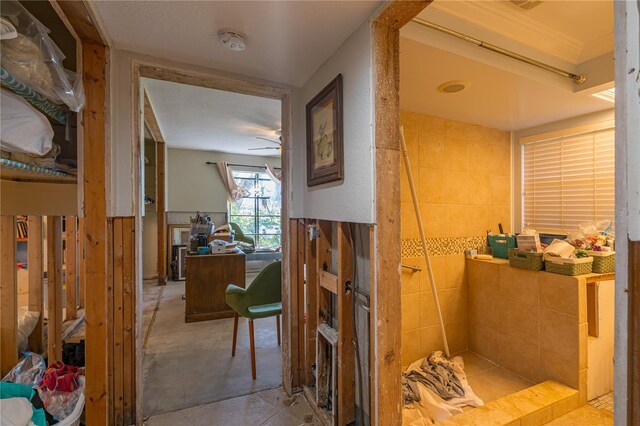 bathroom featuring a ceiling fan and a tile shower