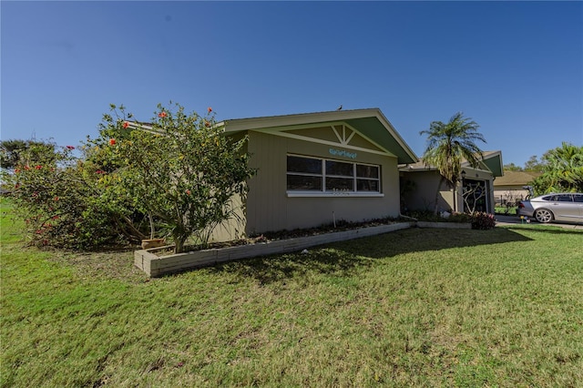 view of side of property featuring a lawn and a garage