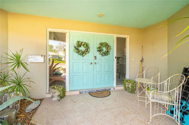 property entrance featuring stucco siding and a patio