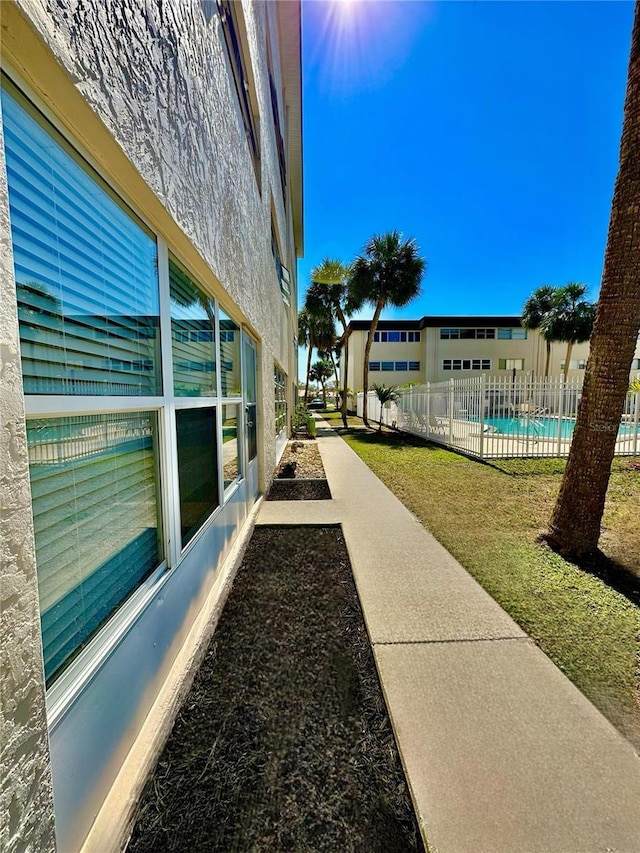 exterior space featuring a fenced in pool, fence, and stucco siding