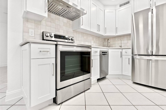 209 NE Lincoln Cir N Unit 105, Saint Petersburg, FL 33702 - kitchen featuring appliances with stainless steel finishes, custom exhaust hood, light countertops, and light tile patterned flooring