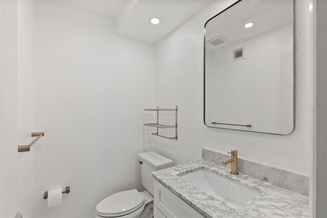 209 NE Lincoln Cir N Unit 105, Saint Petersburg, FL 33702 - half bath featuring toilet, vanity, and recessed lighting