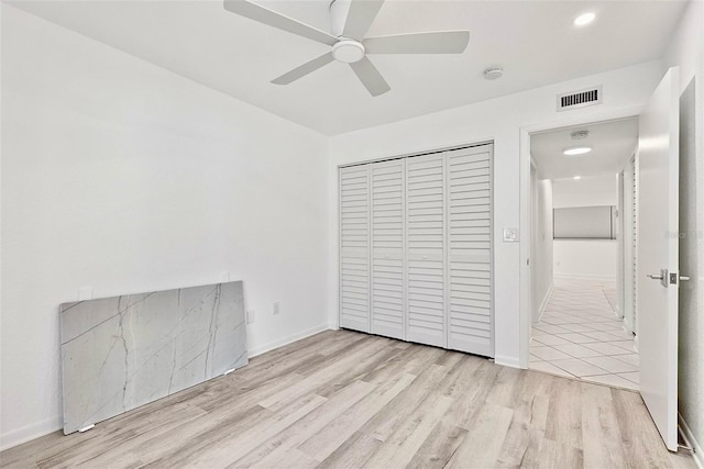 209 NE Lincoln Cir N Unit 105, Saint Petersburg, FL 33702 - unfurnished bedroom with wood finished floors, a closet, recessed lighting, a ceiling fan, and baseboards