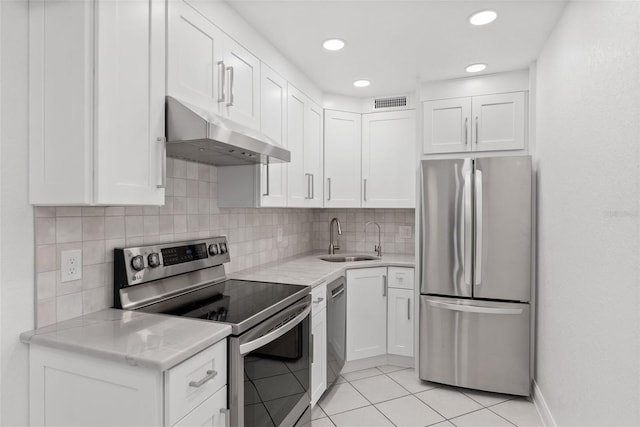 209 NE Lincoln Cir N Unit 105, Saint Petersburg, FL 33702 - kitchen featuring stainless steel appliances, a sink, under cabinet range hood, light countertops, and white cabinets