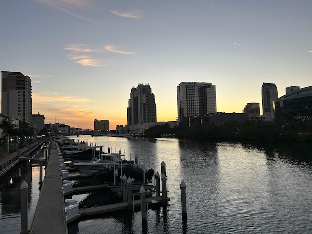 view of dock featuring a water view and a view of city