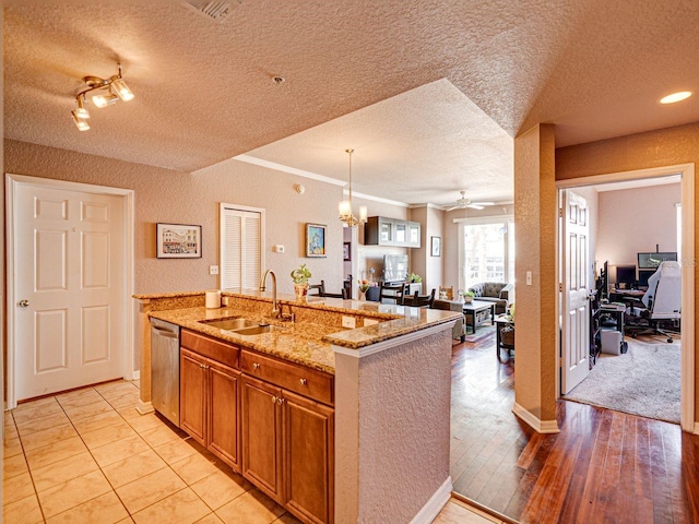 kitchen with dishwasher, open floor plan, a sink, and a textured ceiling