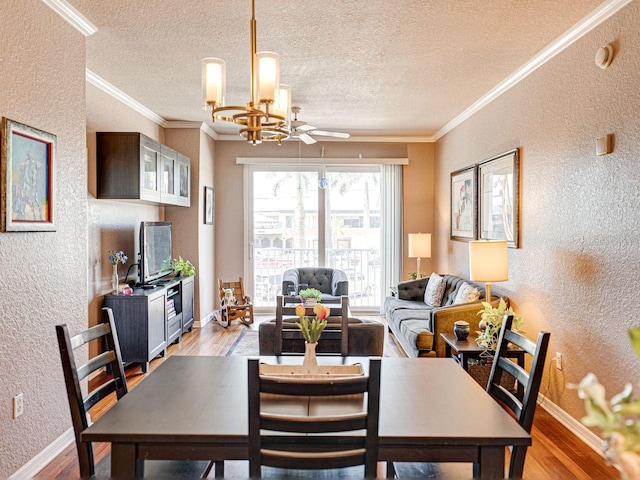 dining space with light wood-style floors, ornamental molding, and a textured wall