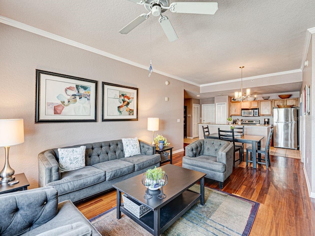living area featuring ornamental molding, ceiling fan with notable chandelier, baseboards, a textured ceiling, and wood finished floors