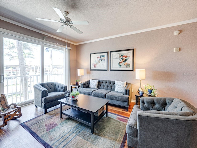 living room with a textured wall, ornamental molding, and wood finished floors