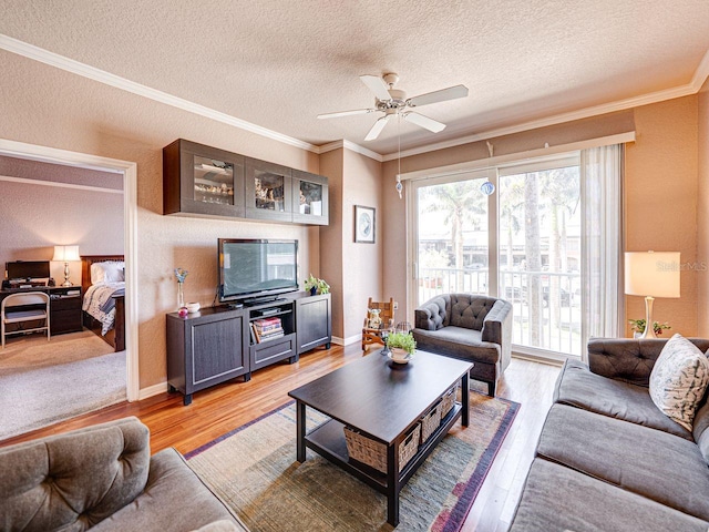 living room with light wood-type flooring, ceiling fan, ornamental molding, and a textured ceiling