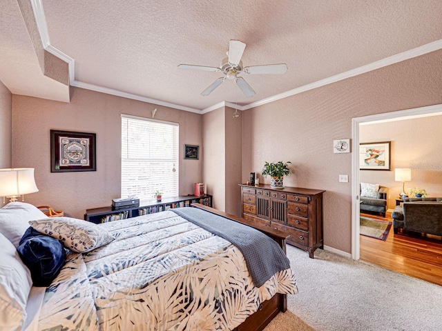 bedroom with a textured wall, carpet floors, ornamental molding, and a textured ceiling