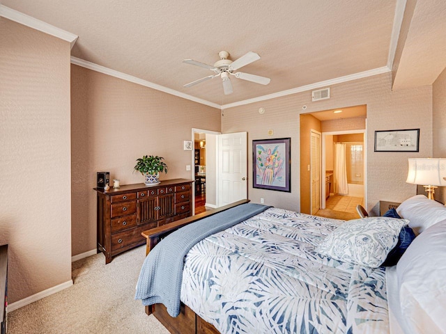 bedroom featuring visible vents, baseboards, ornamental molding, ensuite bath, and light colored carpet