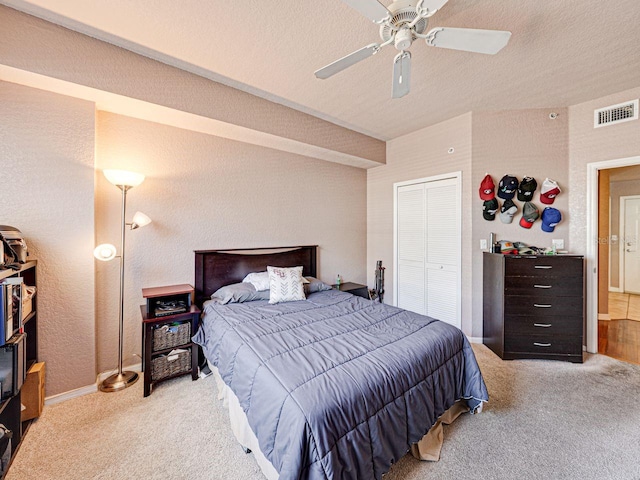 bedroom with a closet, a textured ceiling, visible vents, carpet, and ceiling fan