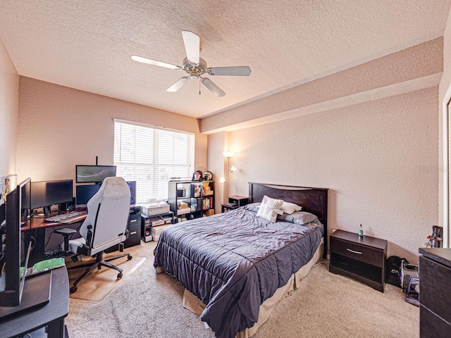 carpeted bedroom featuring a ceiling fan, a textured wall, and a textured ceiling