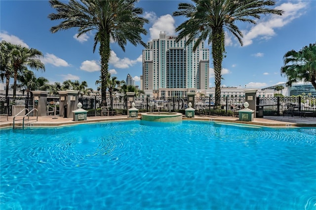 pool with a community hot tub and fence
