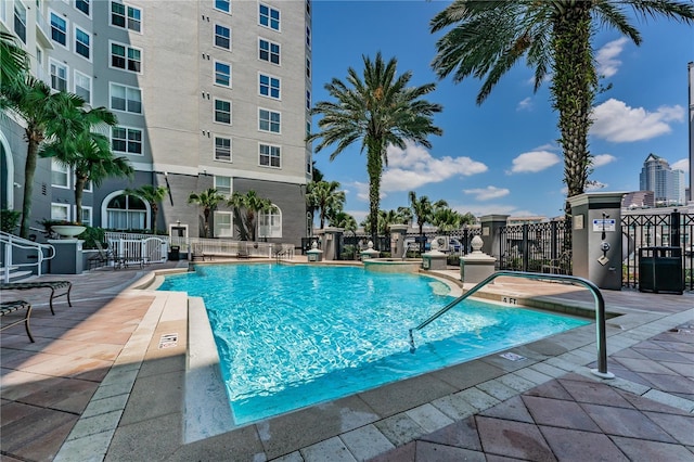 community pool with fence and a patio