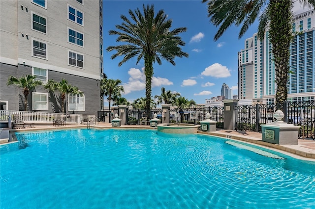 pool with fence and a city view