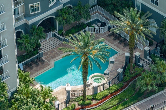 pool featuring a hot tub, fence, and a patio