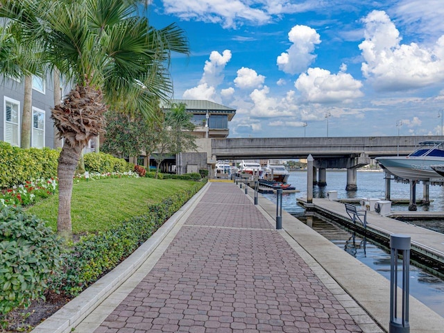 view of dock featuring a lawn and a water view