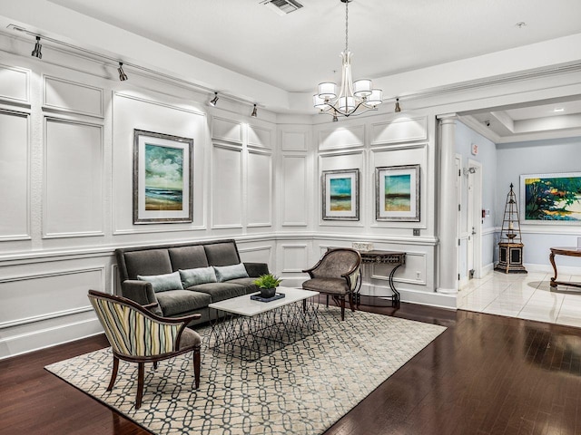sitting room featuring visible vents, wood finished floors, a decorative wall, and a chandelier