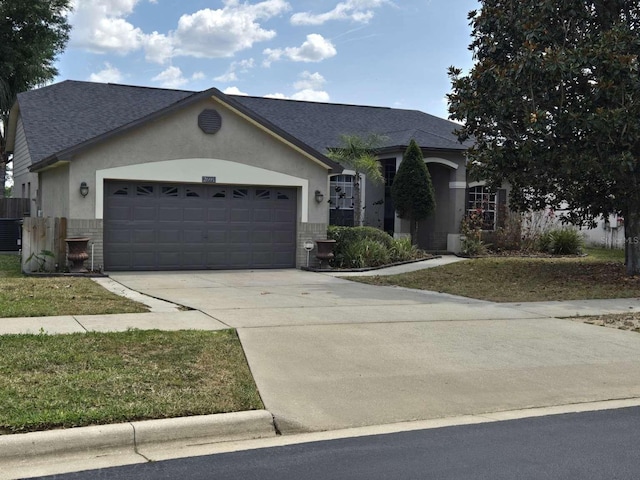 ranch-style home with a garage, driveway, a shingled roof, brick siding, and stucco siding