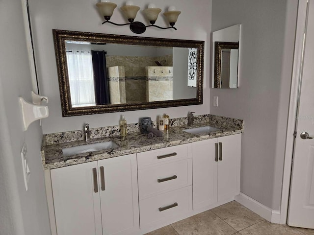 bathroom with tile patterned flooring, baseboards, walk in shower, and a sink