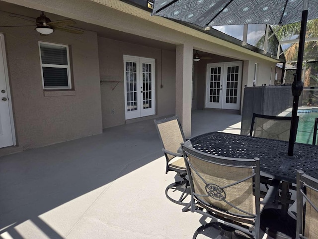 view of patio featuring french doors, a pool, a ceiling fan, outdoor dining space, and a lanai