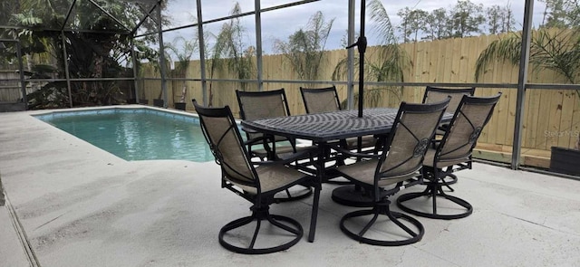 view of swimming pool featuring a fenced in pool, a patio area, glass enclosure, and fence