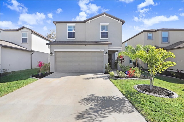 traditional-style house featuring driveway, a front lawn, an attached garage, and stucco siding