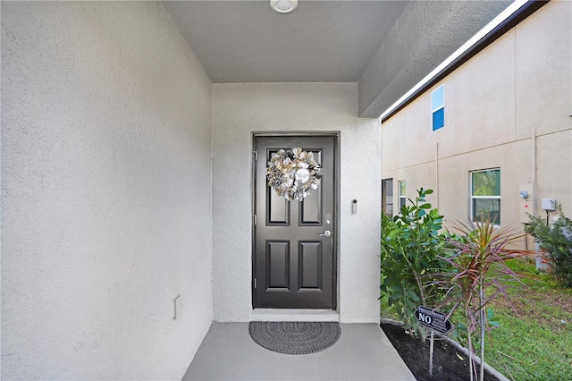 view of exterior entry with stucco siding