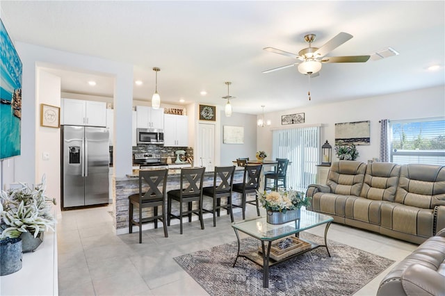 living room with a ceiling fan, recessed lighting, and light tile patterned flooring