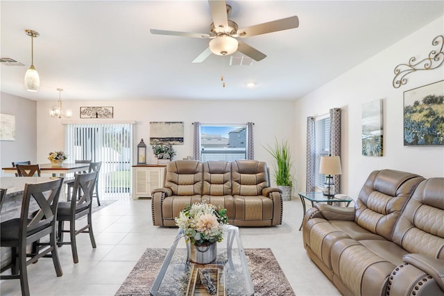 living room featuring light tile patterned floors, ceiling fan with notable chandelier, and visible vents