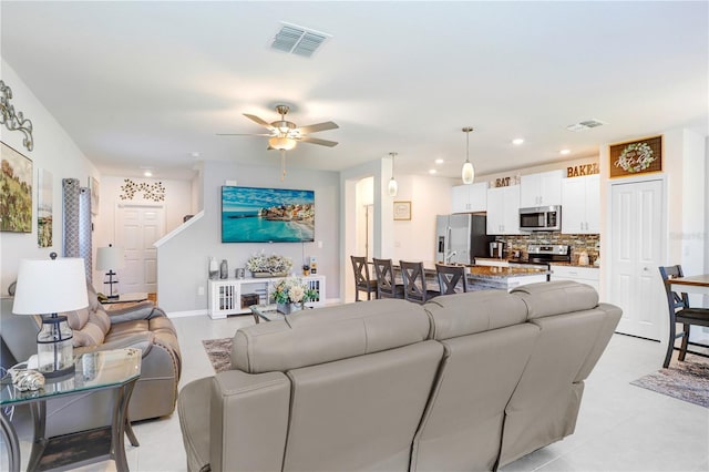 living area with ceiling fan, visible vents, baseboards, and recessed lighting