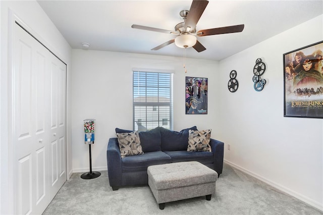 living area with light carpet, ceiling fan, and baseboards