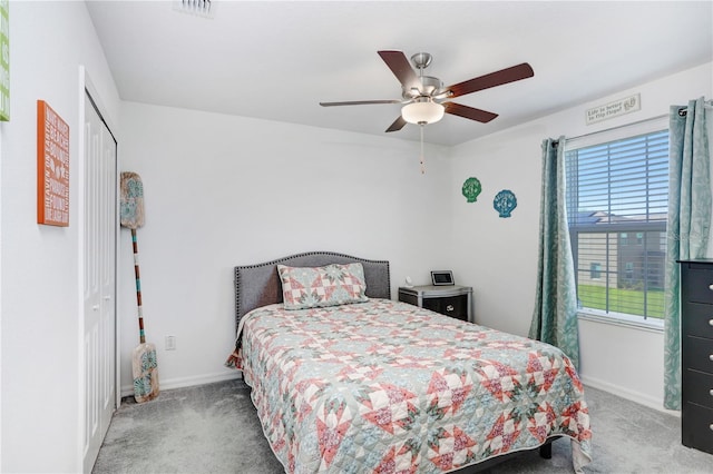 carpeted bedroom featuring a ceiling fan, visible vents, baseboards, and a closet