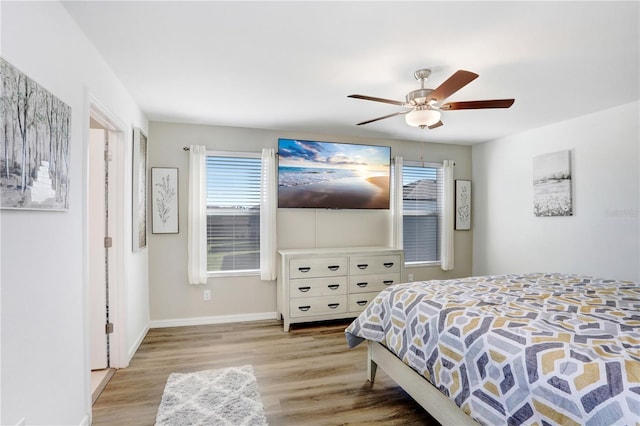 bedroom with wood finished floors, a ceiling fan, and baseboards