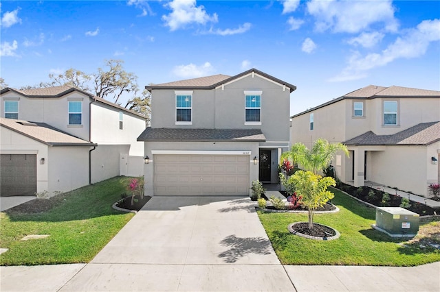 traditional-style house featuring a garage, concrete driveway, a front yard, and stucco siding