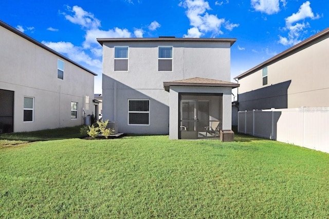 back of house with a sunroom, a yard, fence, and stucco siding