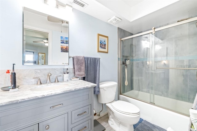 bathroom featuring toilet, combined bath / shower with glass door, vanity, and visible vents