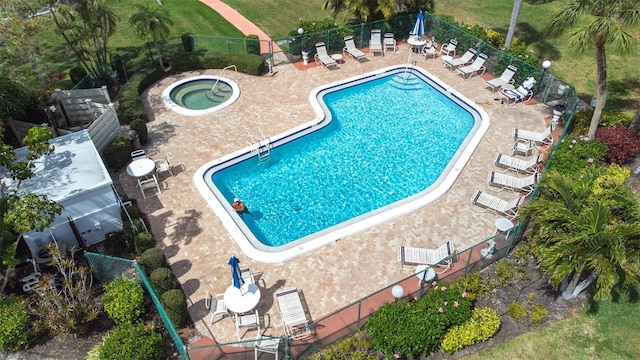 community pool with a patio and fence