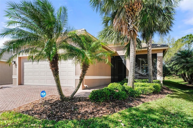 exterior space with decorative driveway, a garage, and stucco siding