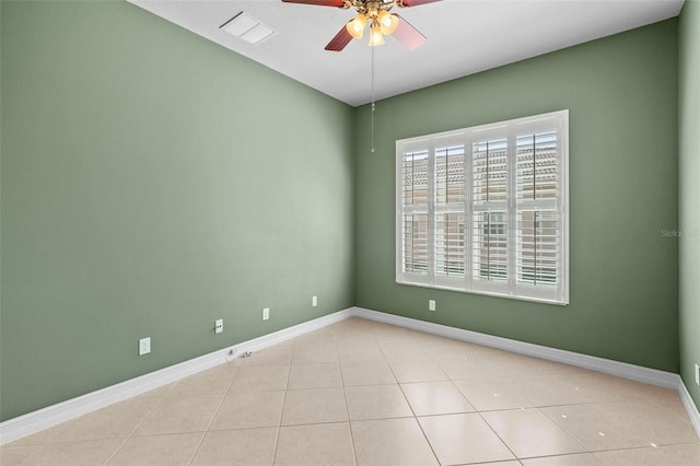 tiled spare room featuring visible vents, baseboards, and ceiling fan