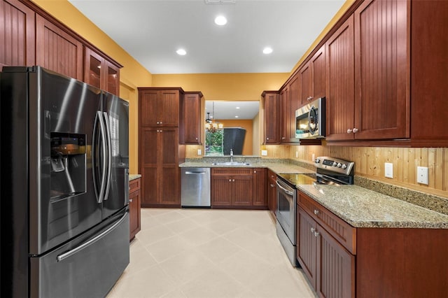 kitchen featuring light stone countertops, recessed lighting, a sink, glass insert cabinets, and appliances with stainless steel finishes