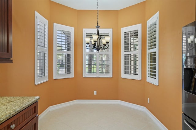 dining area featuring baseboards, a notable chandelier, and light tile patterned flooring