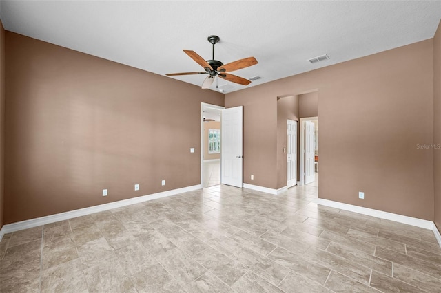 empty room with visible vents, baseboards, and a ceiling fan