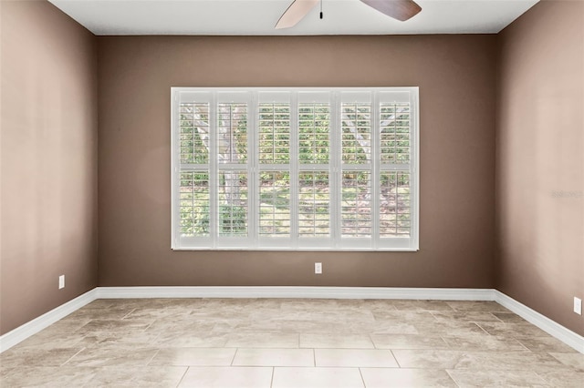 empty room featuring a healthy amount of sunlight, baseboards, and ceiling fan