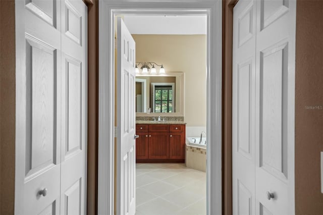 bathroom featuring vanity, tile patterned floors, and a bath