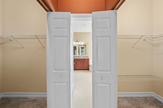 spacious closet featuring light tile patterned floors