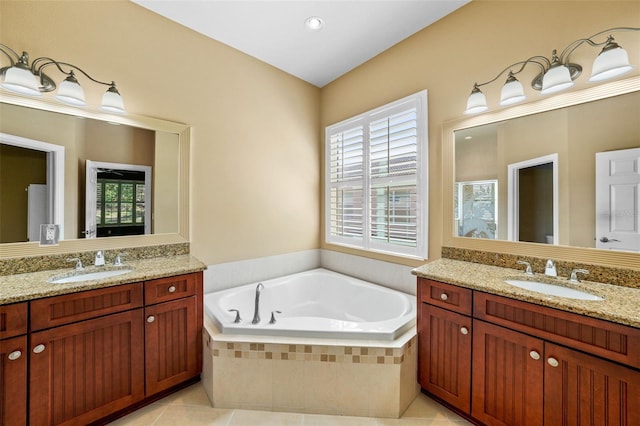 full bathroom featuring tile patterned flooring, two vanities, a garden tub, and a sink