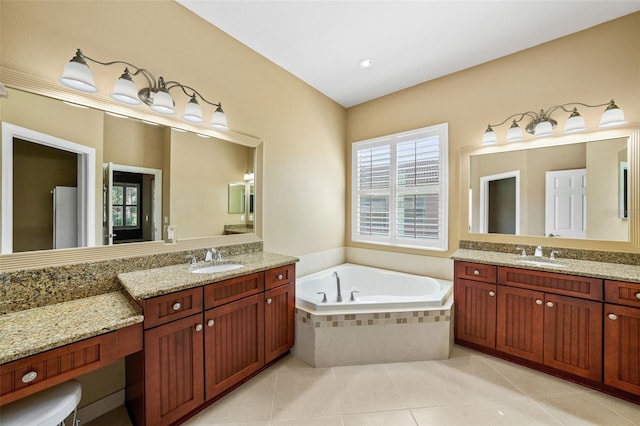 bathroom featuring a sink, two vanities, a bath, and tile patterned floors